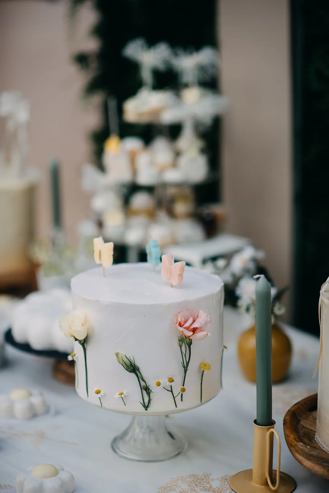 A table set for a celebration with a flower-decorated cake and candles